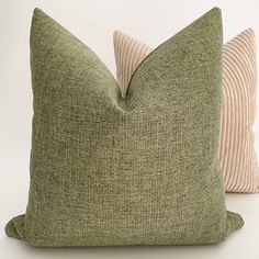 two green and beige pillows sitting next to each other