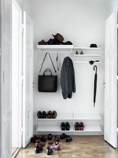 an open closet with shoes and umbrellas on the floor