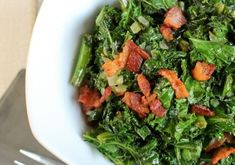 a white bowl filled with greens and bacon