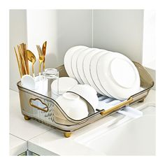 a silver tray with white plates and gold utensils in it on a counter