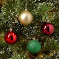 three christmas ornaments hanging from the top of a pine tree with green and red balls