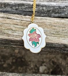 "This is a vintage, cloisonne pendant. It has a pink flower and green leaves on a white background. *I added a necklace on here. Please let me know what color and length you want it to be. This would be a great gift for an anniversary, wedding, Christmas, birthday, or any other occasion. Size: 1 1/4\" x 7/8\"  Condition: Good Maker's Mark: None This model is retired and is no longer in production. All jewelry items come in a gift box." Pink Enamel Jewelry With Flower Charm, White Vintage Charm Medallion Jewelry, Flower Charm Enamel Necklace, Floral Enamel Necklace With Flower Charm, Enamel Flower Charm Necklace, White Medallion Jewelry With Vintage Charm, White Vintage Medallion Jewelry With Charm, Vintage White Necklace With Large Pendant, Vintage Handmade Flower Shaped Necklaces