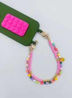 a green phone case with a pink and yellow beaded lanyard attached to it