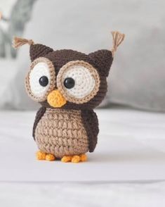 a crocheted owl sitting on top of a bed