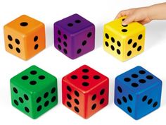 a child's hand is playing with colored dices on a white background,