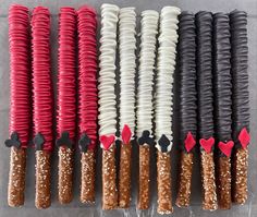 many different types of candy sticks are lined up together on the table with red and black decorations