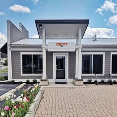 the front entrance to an office building with flowers growing outside