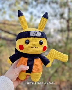 a hand holding up a crocheted pikachu doll