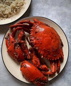 two plates with cooked crabs on them and rice in the backgroung area