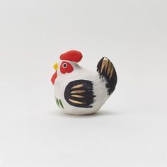 a white and black rooster figurine sitting on top of a table