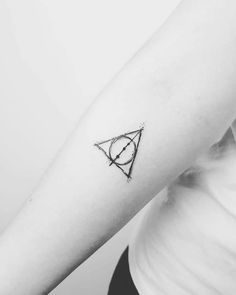 a woman's arm with a small triangle tattoo on the left side of her arm