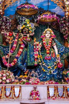 an idol is displayed in the middle of a stage with flowers and garlands around it