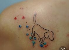 a dog tattoo on the back of a woman's shoulder