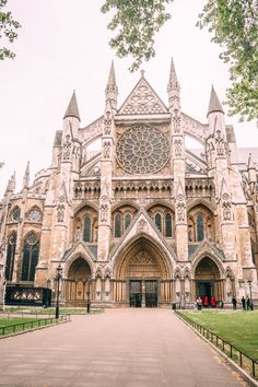 a large cathedral with many windows and spires on it's front entrance, surrounded by green grass