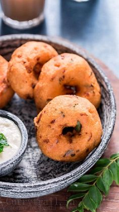 some fried food is on a plate with dipping sauces and a glass of milk