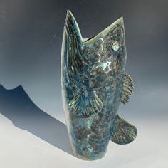 a fish shaped vase sitting on top of a table