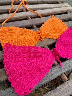 two crocheted bras sitting on top of a wooden bench