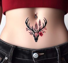 a woman's stomach with a deer skull and flowers on the side, in front of her belly