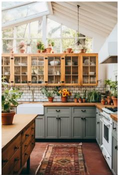 a kitchen filled with lots of plants and wooden cabinets