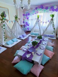 a table set up for a party with plates and napkins on the table, decorated with balloons