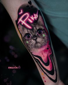 a cat with pink and black ink on the arm