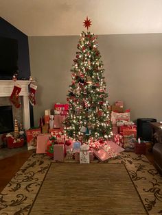 a christmas tree with presents under it in a living room