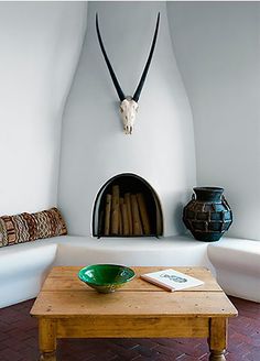 a living room with a couch, coffee table and antelope head on the wall