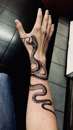 a hand with a snake tattoo on it