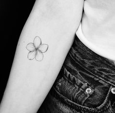 a black and white photo of a woman's arm with a flower tattoo on it