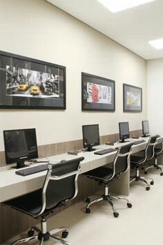 a row of desks with computers sitting on top of them in an office setting