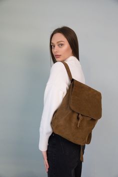 This small leather suede backpack is the perfect vantage accessory for women who appreciate timeless style. Made from soft suede, this mini backpack exudes a sense of luxury. Expertly handmade, every detail showcases the craftsmanship that goes into creating this beautiful bag. With its compact size and suede material, this backpack is both practical and stylish, making it the ideal companion for everyday adventures. ⭐ Backpack made of soft brown suede, fastened with a drawstring with a lock.  ⭐ The shoulder straps are adjustable, so you can easily find the right size for wearing  ⭐ You can carry at your side, handhold, or wear it on your back. ⭐ Size: 13,4x9,4x5,1 in (34 x 24 x 13 cm) ⭐ Material: suede Perfect for gifting, Valentine's Day, Groomsmen, Bridesmaid, Mother's Day, Birthdays, C Travel Satchel With Suede Lining, Soft Leather Suede Travel Satchel, Soft Suede Leather Travel Satchel, Casual Suede Travel Bags, Travel Satchel With Adjustable Strap In Suede, Suede Backpack, Mini Backpack Purse, Backpack For Women, Leather Dye