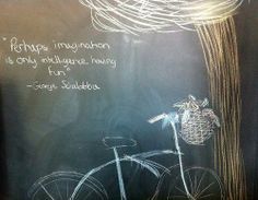 a chalkboard drawing of a bicycle with a quote written on it