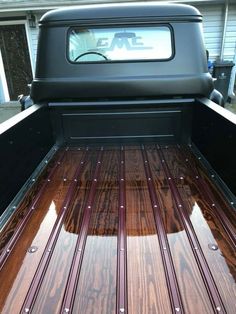 the back end of a pickup truck with wood flooring on it's bed