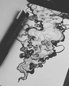 a pen and some ink sitting on top of a piece of paper next to a drawing