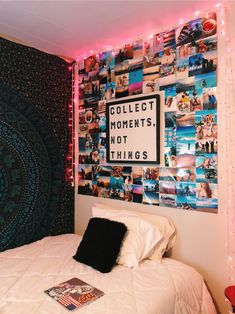 a room with a bed, lights and pictures on the wall above it that says collect moments not things