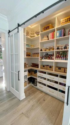 an open pantry with white shelves and wooden flooring in a room that has wood floors