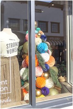 there is a display in the window that has balls and yarn on it as well