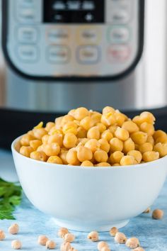 a white bowl filled with chickpeas next to an instant pressure cooker in the background