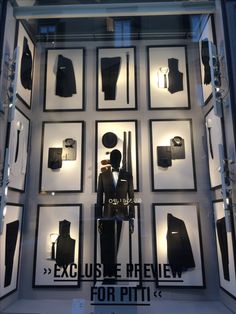 a display case with mannequins and suits in it