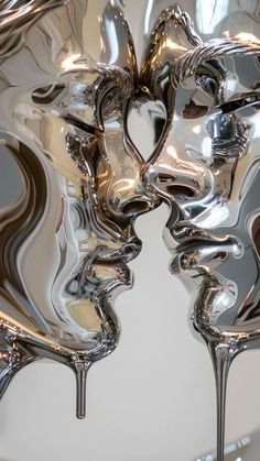 two metal faces are shown in the middle of an abstract sculpture, with one being painted silver