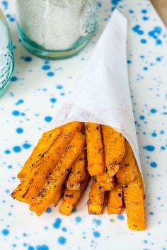 a paper bag filled with cooked carrots on top of a white and blue table