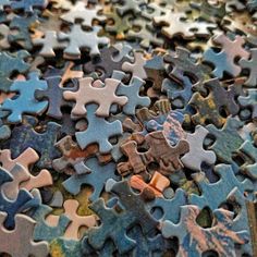 a pile of puzzle pieces sitting on top of a table