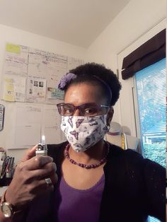 a woman wearing a face mask and holding a lighter