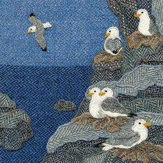 several seagulls are sitting on the edge of a cliff