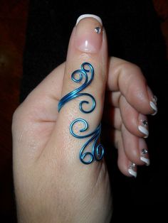 a woman's hand with a blue ring on her thumb and nail polishing