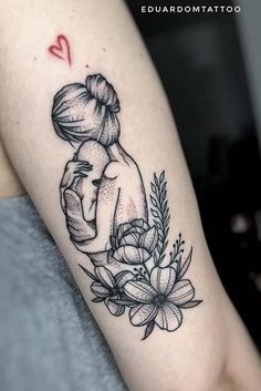 a woman's arm with a tattoo on it that has flowers and a heart