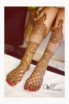 the legs and feet of a woman with henna tattoos