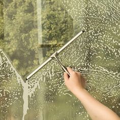 a person is cleaning the glass with a window squirt