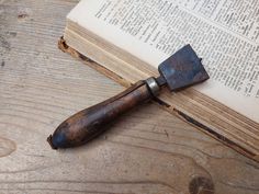 an old book with a knife on top of it