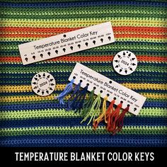 there are some crocheted labels on the table cloth that says temperature blanket color keys